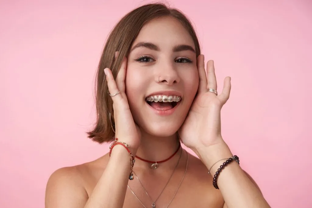Adult woman smiling with braces during orthodontic treatment