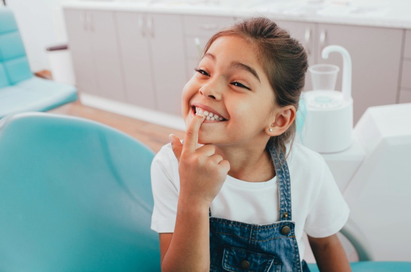 Young girl in an orthodontic chair smiling before expander treatment