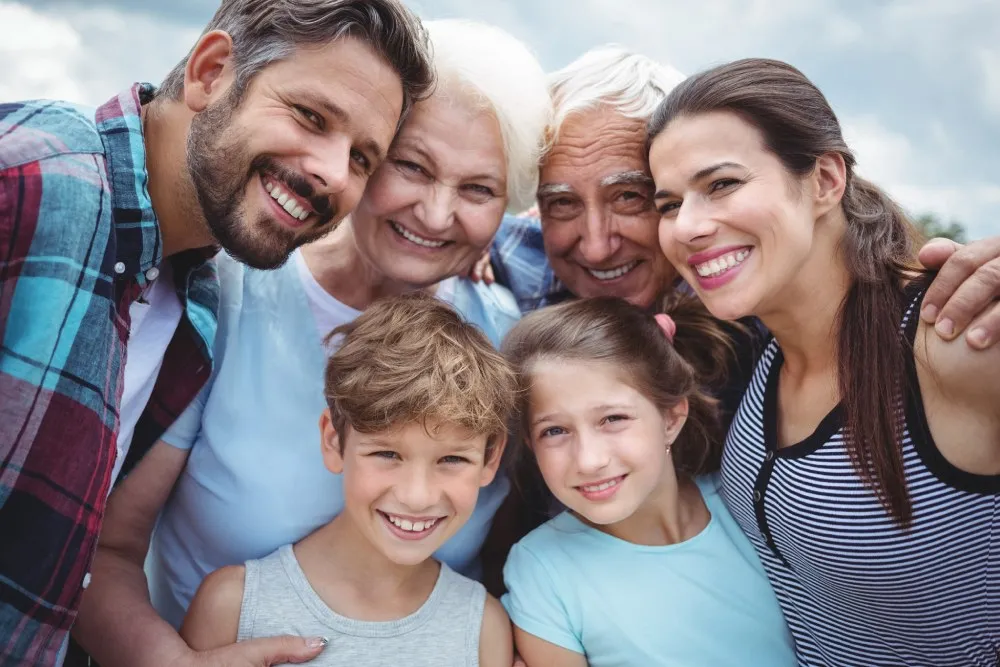 Smiling family standing together outdoors