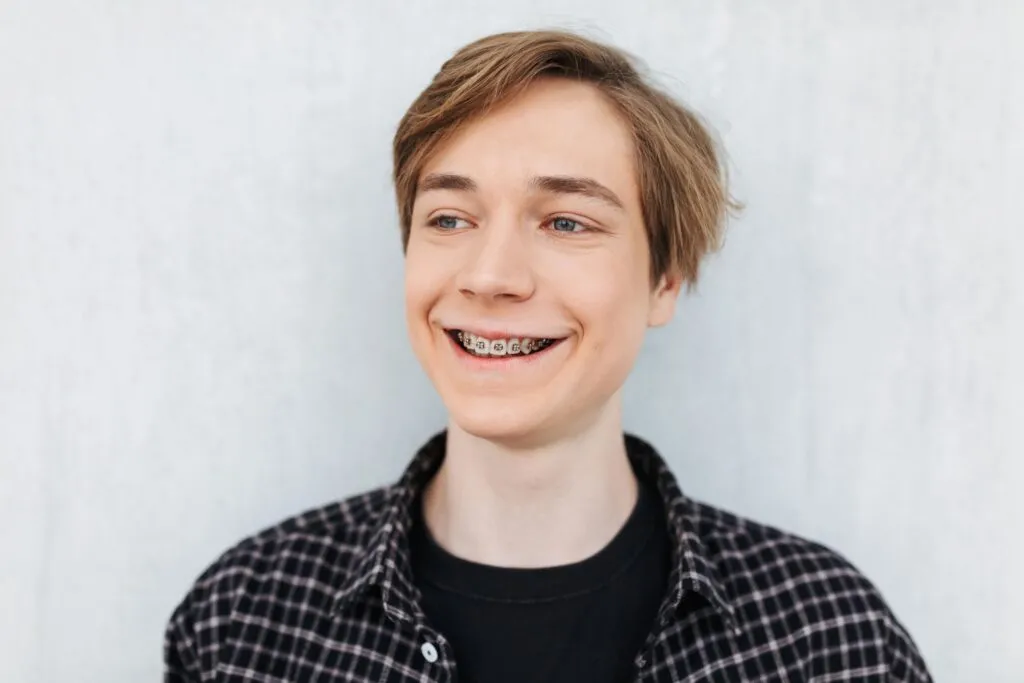 Teen smiling with braces during overbite and overjet correction